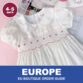 White hand-smocked dress with red details from Cherrysmock for European boutique wholesale